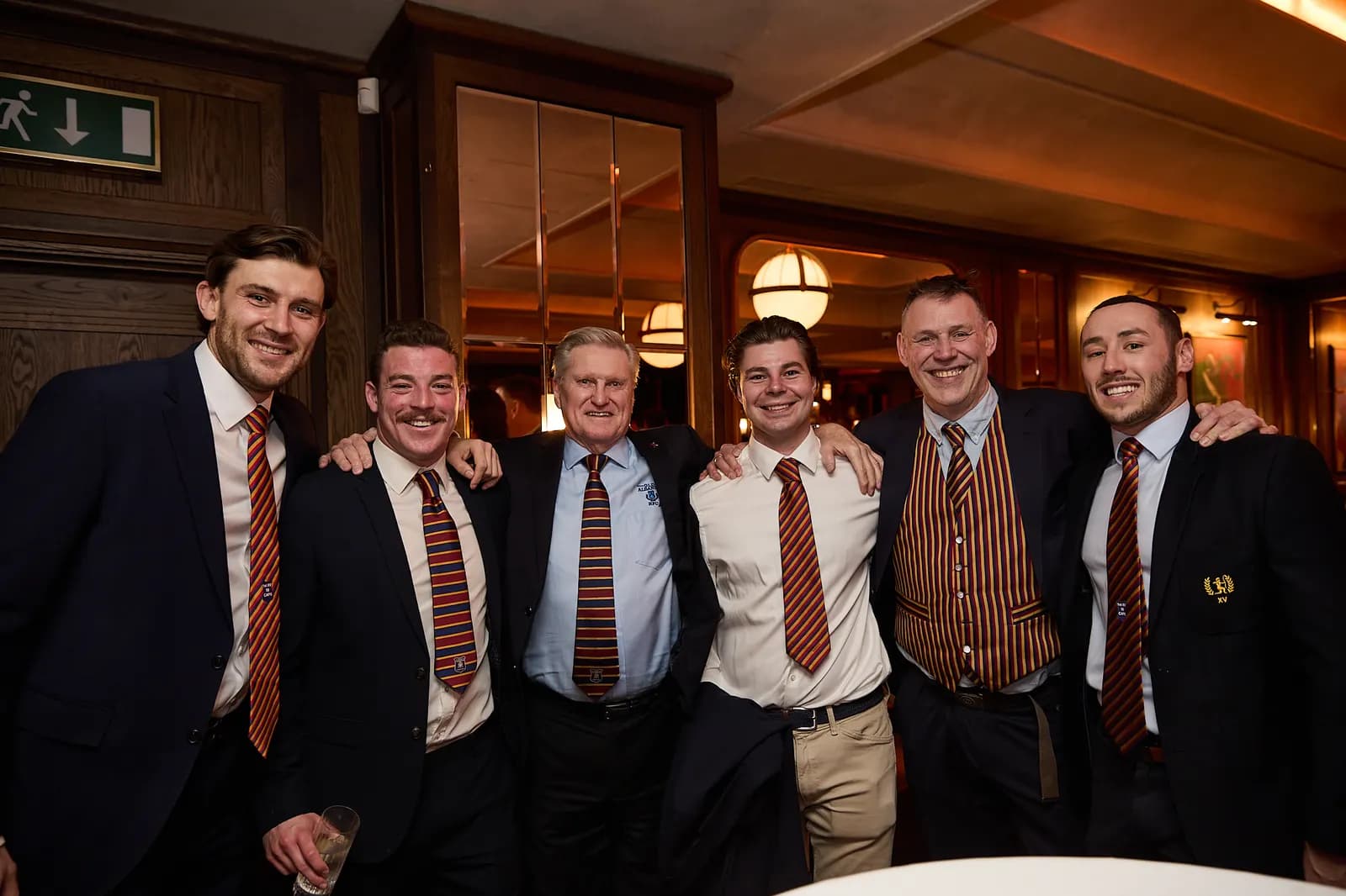 Six members in club ties, arm in arm