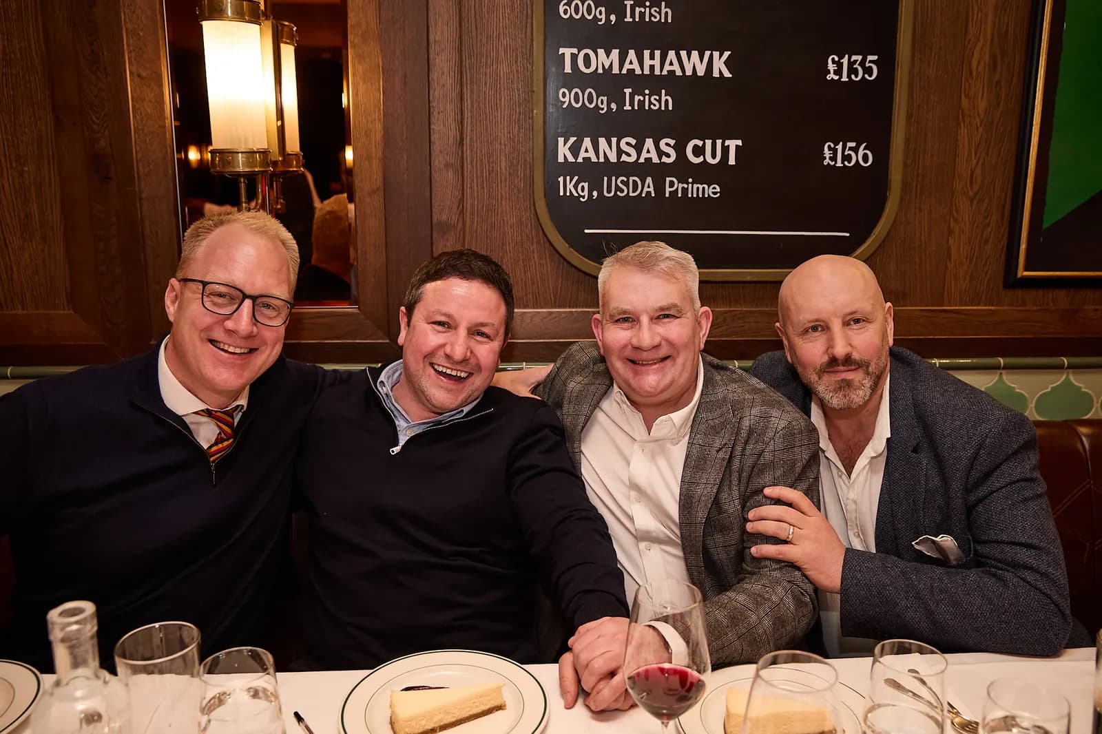 Four friends shoulder to shoulder at their table